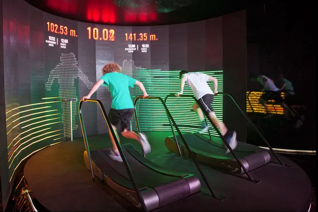 Two men running on the treadmills mid game.