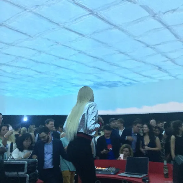 Abra performing in a dome with light blue graphics.