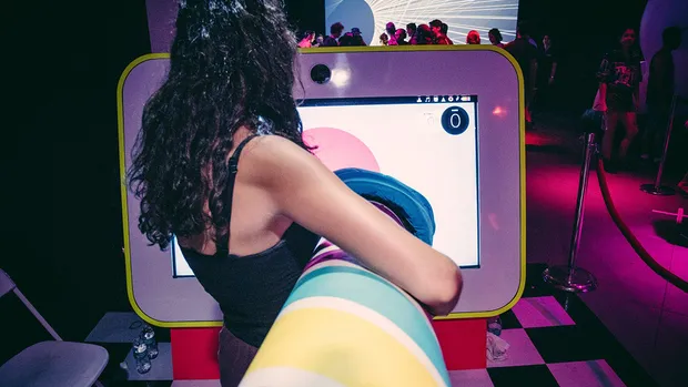 Shot from behind of a woman playing with a foam finger on a tv.