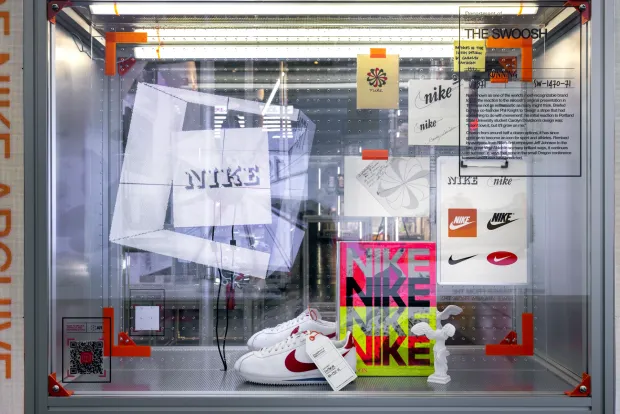 A display case showing nike shoes and posters.