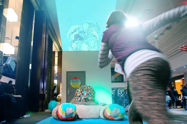A woman running to jump on a giant stuffed bear.